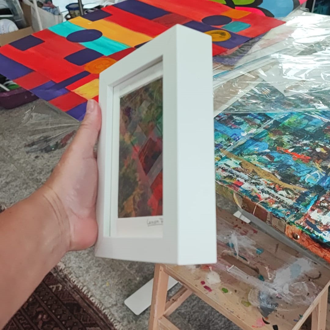 Acrylic painting with vibrant green, yellow, and red tones in a white 3D frame